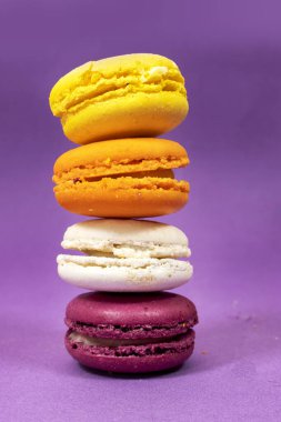 Mor zemin üzerinde izole Fransız renkli kurabiye yığını
