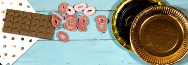 Doğum günü partisi: çikolatalı karton tabaklar ve jöleli şekerler, tahta masanın üzerindeki kağıt peçete. 