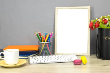 Okul konseptine geri dönelim - kalem kutusu ve kitaplar, defter ve boş ahşap çerçeve fotoğraf ve çiçekler, ahşap masa üzerinde makarna kurabiyeleri