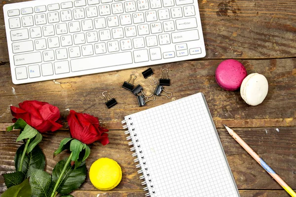 flat lay desktop, Modern computer keyboard, flower's roses  and macarons and notebook or agenda for your text or design