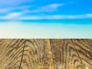 Soyut bulanık gökyüzü bulutlarının önündeki boş ahşap masa. Ürünlerinizi görüntülemek veya montajlamak için kullanılabilir