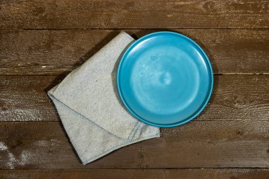 Ahşap masada boş seramik mavi tabak 