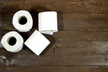 Tuvalet kağıdı ahşap bir masada yuvarlanıyor.