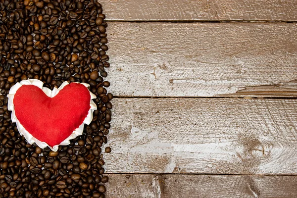 红心烤咖啡豆在木桌上 爱喝咖啡的概念 — 图库照片
