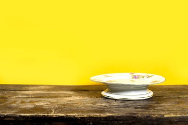 boş çiçek standı Kek ahşap masa üzerinde sarı arkaplan