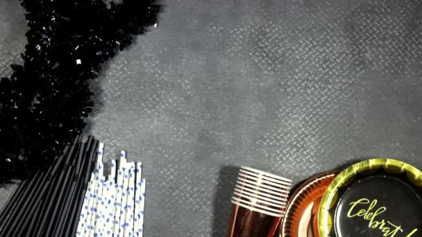 生日宴会的概念 纸盘与卡片庆祝文字和一次性杯子 稻草和灰色背景的黑金 — 图库视频影像