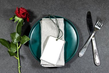 Şenlikli moda masası. Tabakta kırmızı güllü özel bir davetiye var. Konukların şenlik masasındaki yerlerinde dağılımı