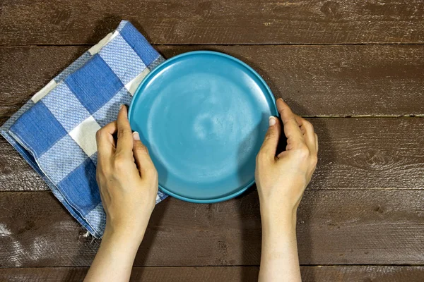 Hand Holding Empty Ceramic Blue Plate Wood Table — Φωτογραφία Αρχείου