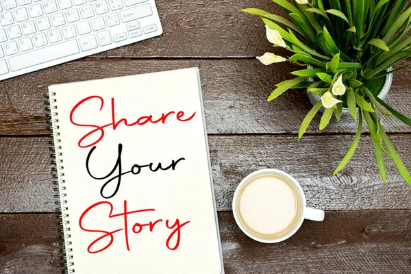 share your story concept on notebook with cup of coffee and keyboard, lilies flowers