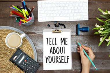 hand writing Tell me about yourself, text words typography written on clipboard desktop, life and business motivational inspirational concept