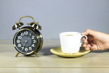 Çalar saat 7 'de bir kadının bir fincan kahve içtiğini gösteriyor. çalışma konseptine hazır