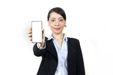 Trendy Mobile Phone. Portrait of cheerful young woman holding cellphone with black blank screen in hand, showing device. Gadget with empty free space for mock up, selective focus