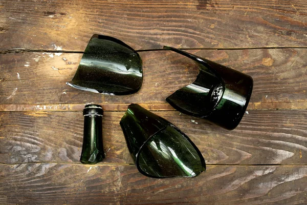 Glass shards, broken wine bottle isolated on wood table
