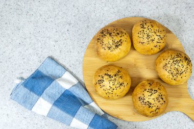 Tahtada susamlı ev yapımı hamburger çörekleri.