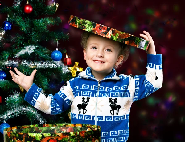 Menino no fundo da árvore de Natal — Fotografia de Stock