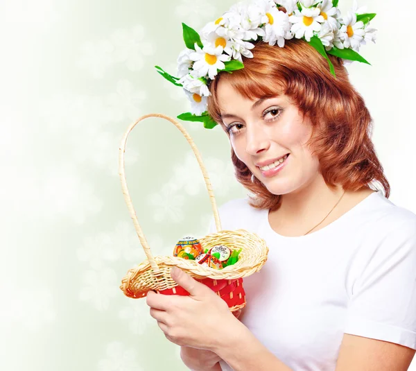 Young woman holding a basket with Easter eggs — Stock Photo, Image