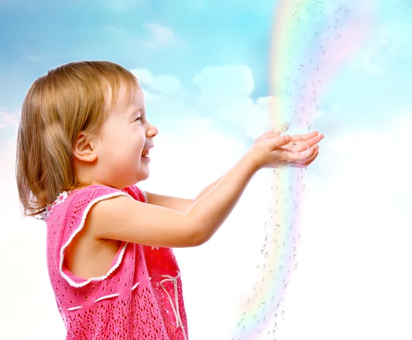 küçük kızı yağmur damlaları arka plan üzerinde yakalar.