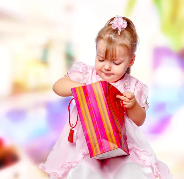 Retrato da menina no shopping segurando um presente — Fotografia de Stock