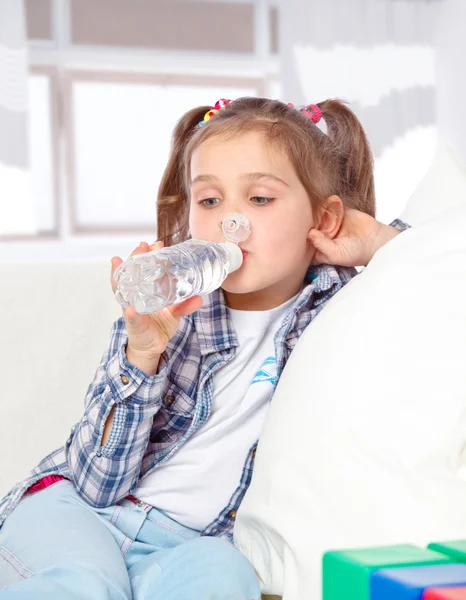 Portrait of a cheerful little girl drinking water from a bottle — Stock Photo, Image