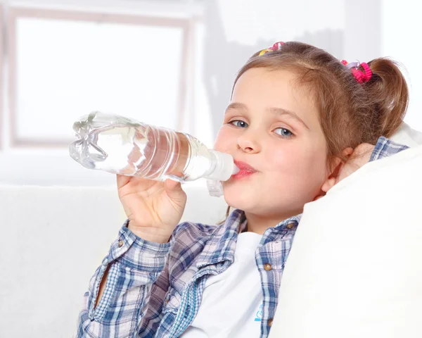 Portrait of a cheerful little girl drinking water from a bottle — Stock Photo, Image