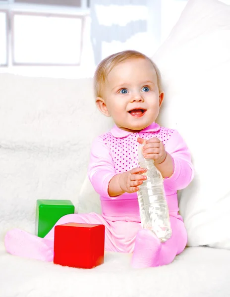 Portrait of a cheerful little girl drinking water from a bottle — Stock Photo, Image