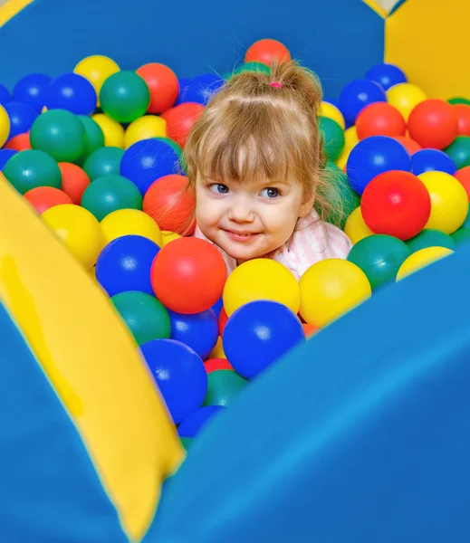 Bambina che gioca nelle palle della piscina — Foto Stock