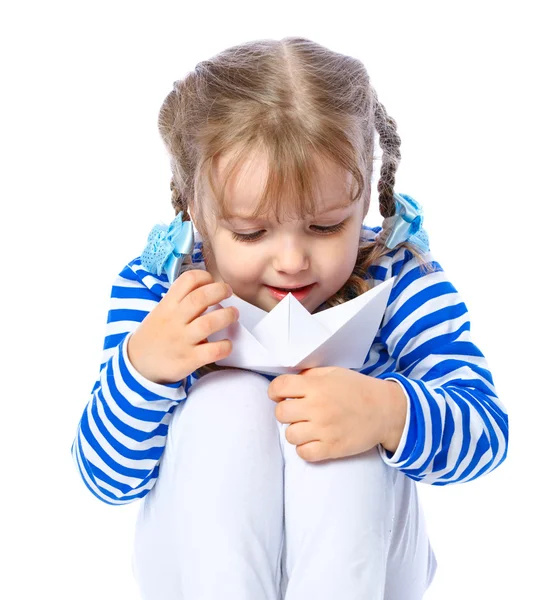 Ritratto di una bambina che regge una barca di carta su uno schienale bianco — Foto Stock