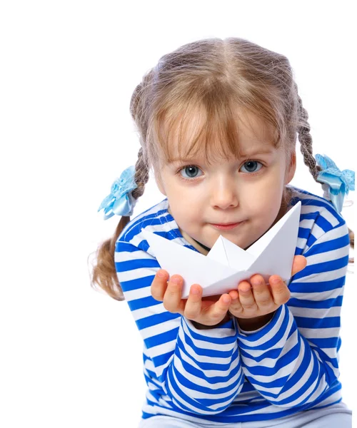 Retrato de una niña sosteniendo un barco de papel sobre un fondo blanco — Foto de Stock