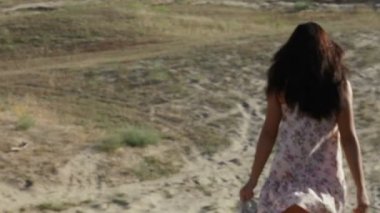 Kız, aşağı doğru kumlu bir dağda koşar