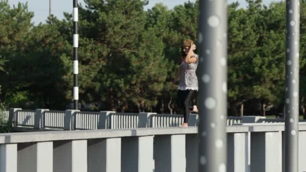 Fille saute sur une clôture de granit 