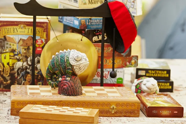 Figurinha de camaleão em um tabuleiro de xadrez . — Fotografia de Stock