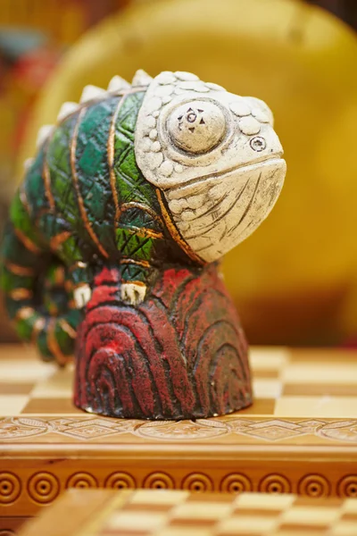 Figurina di camaleonte su una scacchiera . — Foto Stock