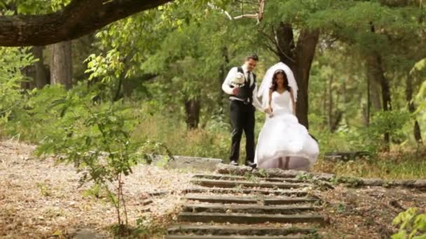 Una pareja recién casada baja por una vieja escalera — Vídeo de stock