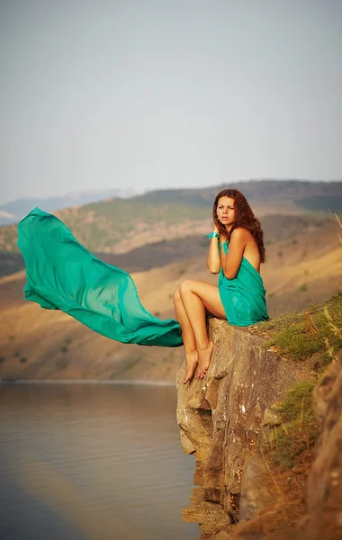 Girl sitting on the edge of a cliff — Stock Photo, Image