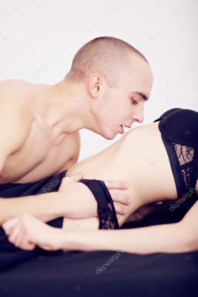 Muscular man kisses the girl in underwear