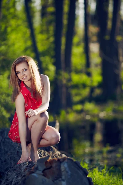 Girl siting on a log — Stock Photo, Image