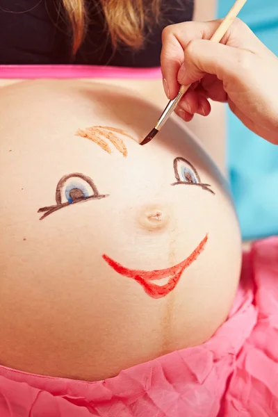 Беременная девушка с картинкой — стоковое фото