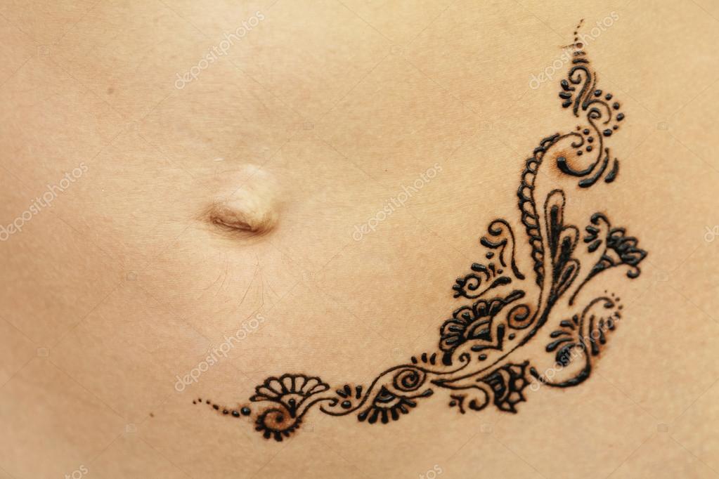 Download - Mehndi on her stomach at the girl near the navel - Stock Image. 