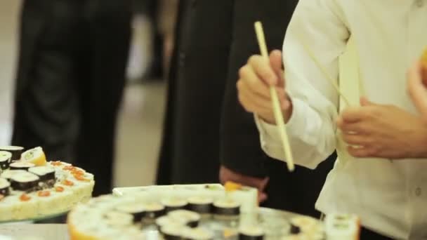 客人在一个节日的鸡尾酒会上采取寿司 — 图库视频影像