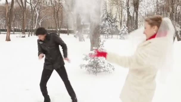 Молодята кидають сніжки один на одного — стокове відео