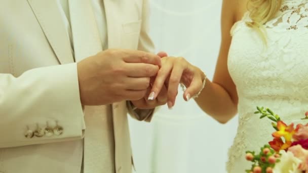 Lo sposo indossa una fede nuziale sulla mano della sposa. La sposa indossa la sposa anello . — Video Stock