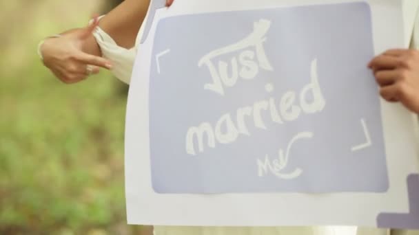 Pareja sosteniendo signo recién casado — Vídeos de Stock