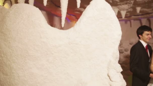 Young couple kissing hiding behind a veil in therapeutic salt cave — Stock Video