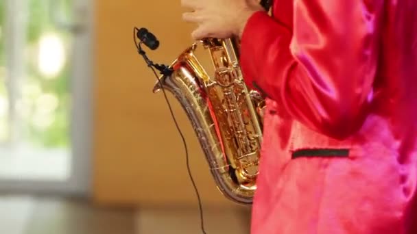 Hombre con traje rojo, tocando el saxofón — Vídeo de stock