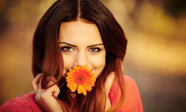 Flicka med en blomma i munnen — Stockfoto