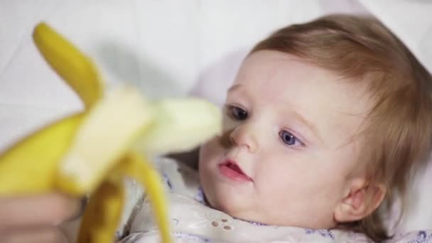 Meisje van de baby is het eten van een banaan. — Stockvideo