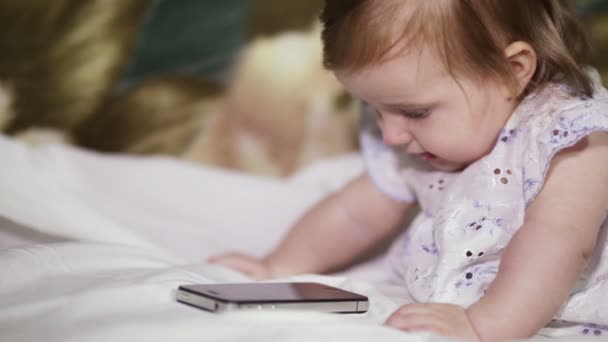Kız bebek için bir cep telefonu dinleme. — Stok video