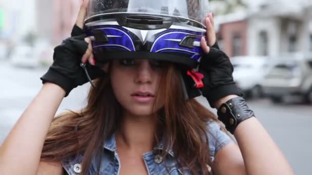 Красивая девушка берет мотоциклетный шлем и улыбается — стоковое видео