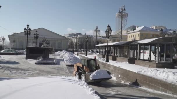 Yoğun bir kar yağışı sonrasında Manezhnaya Meydanı 'nda işçiler ve bir traktör kar temizliyor. — Stok video