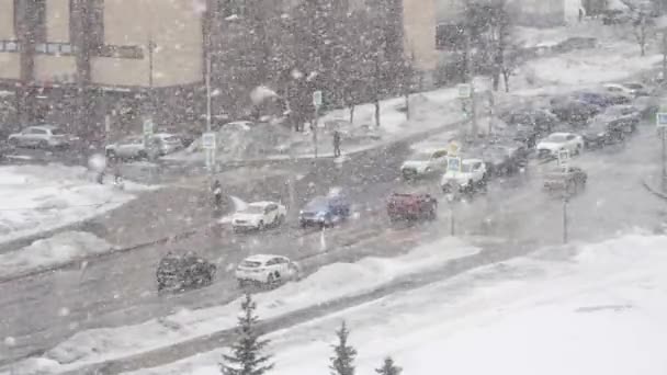 Grote sneeuw op de achtergrond van een drukke kruising van Gorchakov Street en Akademik Lazarev Street in Moskou — Stockvideo